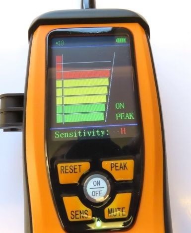 Digital device with a screen displaying 'ON PEAK' and control buttons on an orange and black casing.