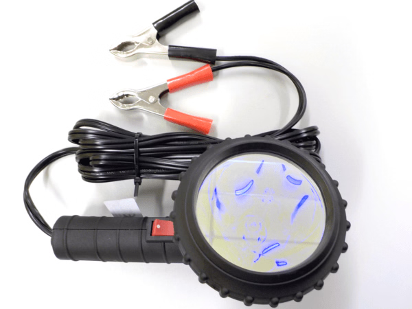 Black handheld device with blue light display and red clamps