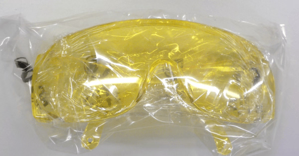 Yellow safety goggles in clear plastic packaging